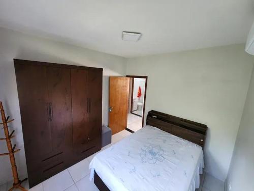 ein Schlafzimmer mit einem Bett und einem Holzschrank in der Unterkunft Residêncial Maria de Castro in Mairiporã