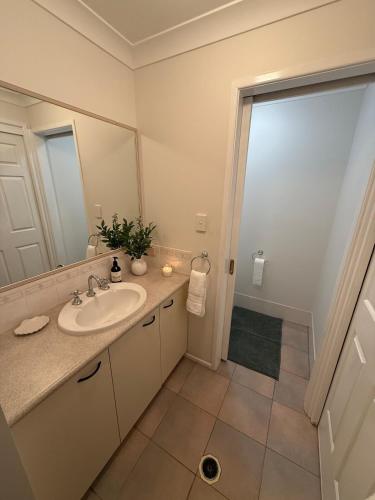 a bathroom with a sink and a mirror at Pet Friendly - Plunge Pool Canal Sunset View - Private Jetty in Bongaree