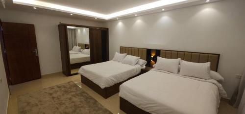 Una habitación de hotel con dos camas y un espejo. en Elhambra First Avenue, en Hurghada