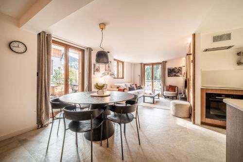 une cuisine et un salon avec une table et des chaises dans l'établissement Rosalia Alpina 3 Chambres, à Morzine