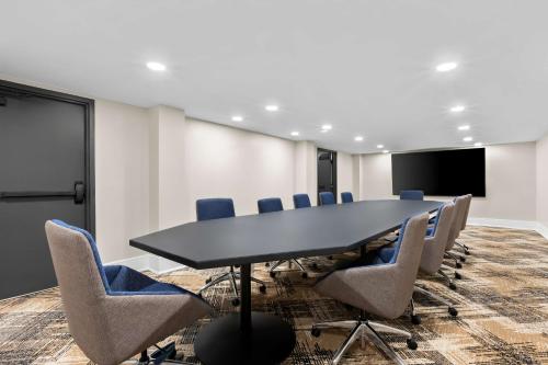 a conference room with a black table and chairs at Latitude Suites Tinton Falls Eatontown - BW Premier Collection in Tinton Falls