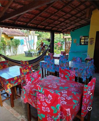a group of tables and chairs with red and blue covers at Pousada Arco-Iries de Itaúnas ES in Conceição da Barra