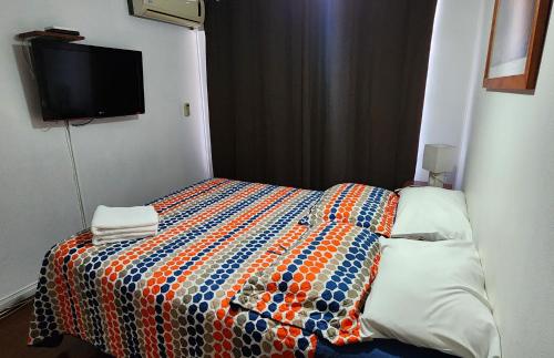 a bedroom with a bed with a colorful quilt at Santiago Center Apart in Santiago