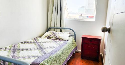 a small bedroom with a bed and a dresser at Santiago Center Apart in Santiago