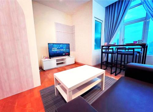 a living room with a television and a table in it at KL Sentral Dua Sentral Cozy Homestay Apartments by Hollywood Homes #FreeCarPark in Kuala Lumpur