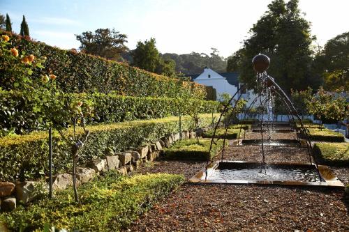 a garden with a water fountain in the middle at The Cellars-Hohenort in Cape Town