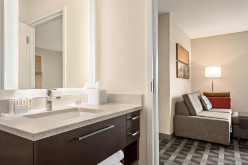 a bathroom with a sink and a couch in a room at TownePlace Suites by Marriott Janesville in Janesville