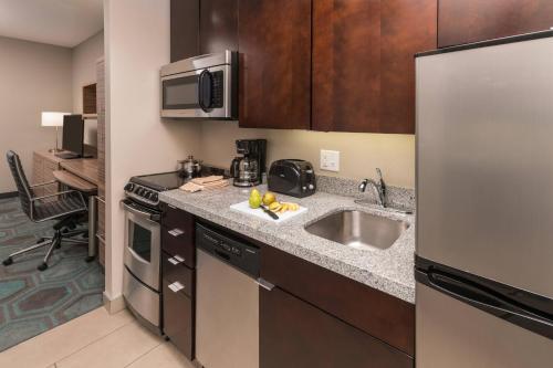 a small kitchen with a sink and a refrigerator at TownePlace Suites by Marriott Chicago Schaumburg in Schaumburg