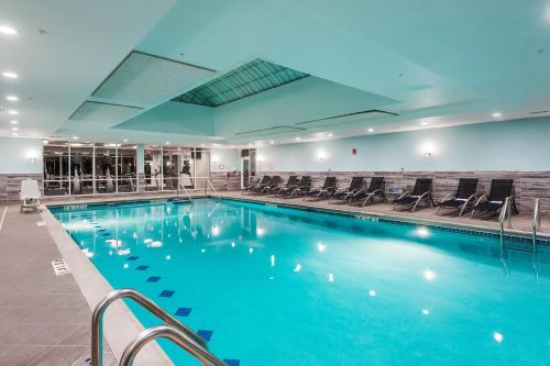 a large swimming pool with chairs in a building at TownePlace Suites by Marriott Chicago Schaumburg in Schaumburg