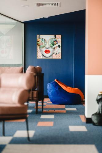 a living room with a couch and a blue wall at Kepler Club Riga Airport Hotel - Airside EU Transit Area - Only Schengen in Rīga