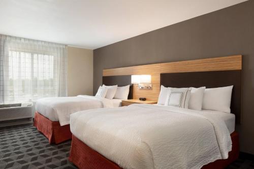 a hotel room with two beds and a window at TownePlace Suites Cedar Rapids Marion in Cedar Rapids