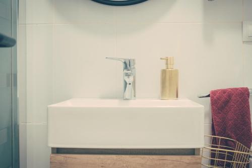カステリョン・デ・ラ・プラナにあるCasa del Barrioのバスルーム(白い洗面台、赤いタオル付)