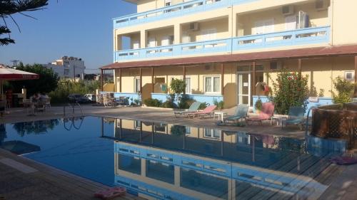 a hotel with a swimming pool in front of a building at Eleni Palace in Amoudara Herakliou