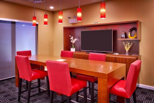a conference room with a wooden table and red chairs at TownePlace Suites by Marriott Missoula in Missoula