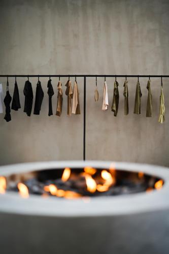 a row of shirts hanging on a clothes line next to a fireplace at Esh Hotel & Spa in Nosara