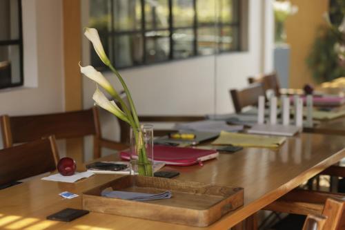 a wooden table with a vase with flowers in it at Casa Decu in Mexico City