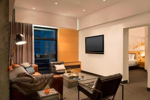 a living room with a couch and a television at Hotel PUR, Quebec, a Tribute Portfolio Hotel in Quebec City