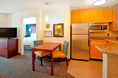 a kitchen with a table and a refrigerator at Residence Inn by Marriott Portland Airport at Cascade Station in Portland