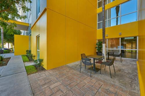 a yellow building with a table and chairs at City Express by Marriott Queretaro Jurica in Querétaro