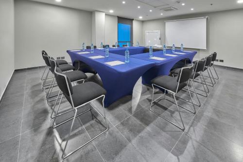 a long blue table and chairs in a room at City Express by Marriott Queretaro Jurica in Querétaro