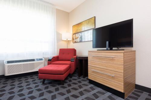 a living room with a red chair and a television at TownePlace Suites by Marriott Edmonton South in Edmonton