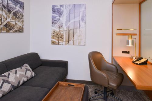 a living room with a couch and a desk at SpringHill Suites Durham Chapel Hill in Durham