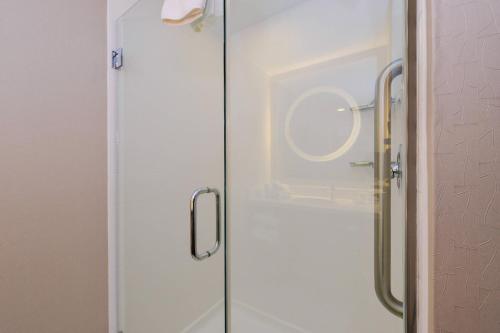a shower with a glass door with a mirror at SpringHill Suites Durham Chapel Hill in Durham