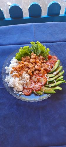 a plate of food with rice and vegetables on a table at Villa Karina B&B in Itaparica Town