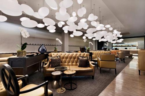 a lobby with couches and chairs and a chandelier at Protea Hotel Fire & Ice! by Marriott Pretoria Menlyn in Pretoria