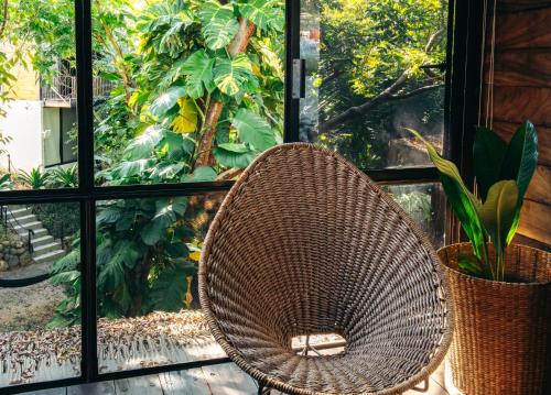a wicker chair sitting in front of a window at Casa Selva Sayulita in Sayulita