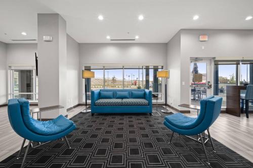a waiting room with blue furniture and windows at TownePlace Suites Waco Northeast in Waco