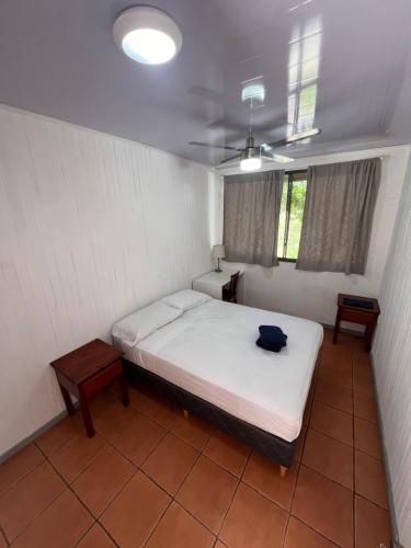 a bedroom with a bed and two tables in it at Blue Dream Kite Boarding Resort Costa Rica in Puerto Soley