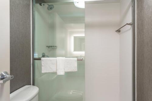 a bathroom with a shower with a toilet and towels at SpringHill Suites by Marriott Austin The Domain Area in Austin