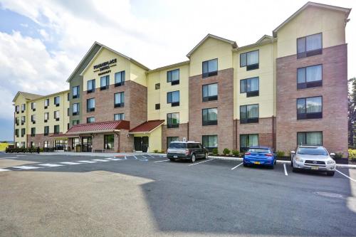 a hotel with cars parked in a parking lot at TownePlace Suites by Marriott Dover Rockaway in Dover