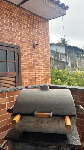 a suitcase sitting on a table in front of a brick building at Estalagem pé na areia in Arraial do Cabo