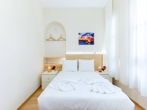 a hotel room with a white bed and white walls at Otantik Guesthouse in Istanbul