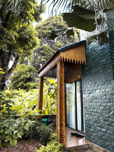 a small building with a glass door in a garden at TRANG AN LUXURY HOMESTAY in Ninh Binh