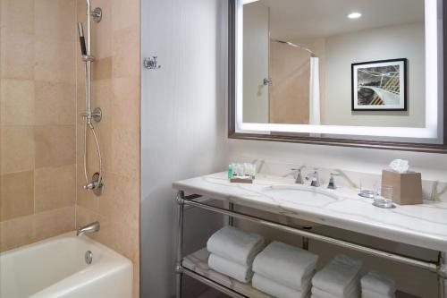 a bathroom with a sink and a mirror and a tub at The Westin Poinsett, Greenville in Greenville