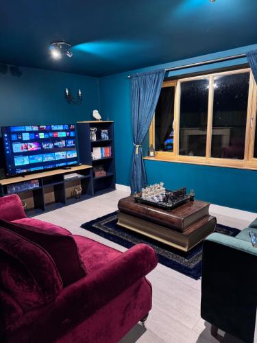 a living room with a couch and a tv at Hogwarts apartment in Abbots Langley