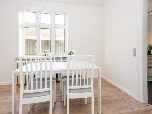 a white dining room with a white table and chairs at Charming Retreat in Ringkobing - By Traum Ferienwohnungen in Ringkøbing