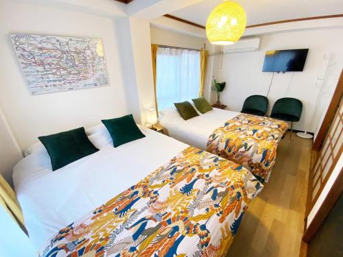 a bedroom with two beds and a tv at 1min walk to sta, Many food, Near Shibuya and HND in Tokyo