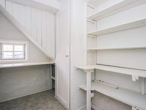 a walk in closet with white shelves and a window at Charming Retreat in Ringkobing - By Traum Ferienwohnungen in Ringkøbing