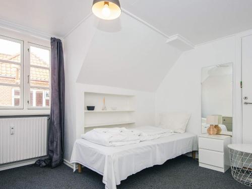 a white bedroom with a bed and a mirror at Charming Retreat in Ringkobing - By Traum Ferienwohnungen in Ringkøbing