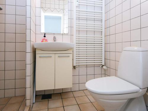 a white bathroom with a toilet and a sink at Holiday home in Denmark in Ringkøbing