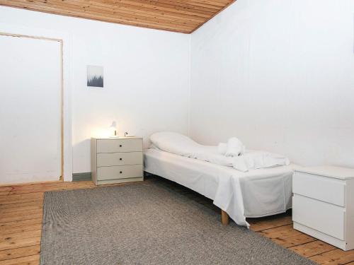 a white bedroom with a bed and a dresser at Holiday home in Denmark in Ringkøbing