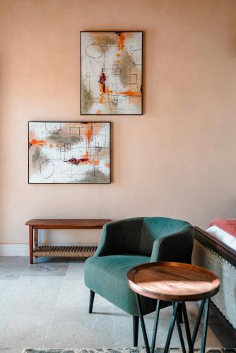 a living room with a green couch and two paintings at Hábimo - Valle de Guadalupe in Valle de Guadalupe