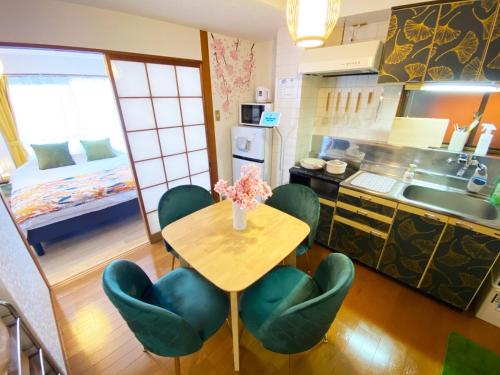a kitchen with a wooden table and green chairs at 1min walk to sta, Many food, Near Shibuya and HND in Tokyo