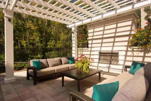 a pergola with a couch and a table on a patio at TownePlace Suites by Marriott Charleston Airport/Convention Center in Charleston