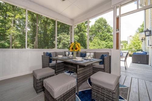 a screened in porch with a table and chairs at Arcade, Ping Pong, Hot Tub, Gas Grill, & King Bed in Kernersville