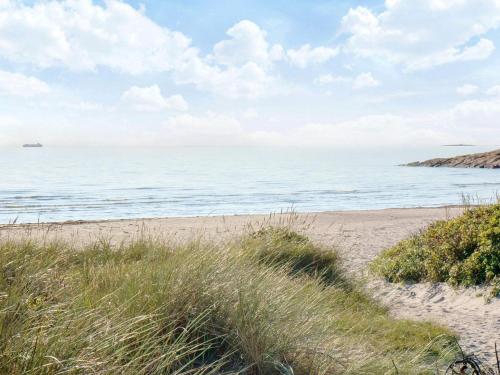 a sandy beach with the ocean in the background at 4 star holiday home in Heberg in Heberg